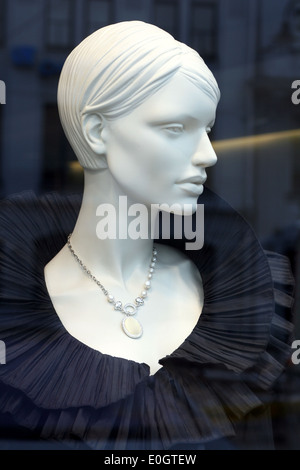 Luxus-Mannequin gekleidet in eleganten schwarzen Abendkleid auf dem Display mit Reflexionen über die Schaufenster Stockfoto