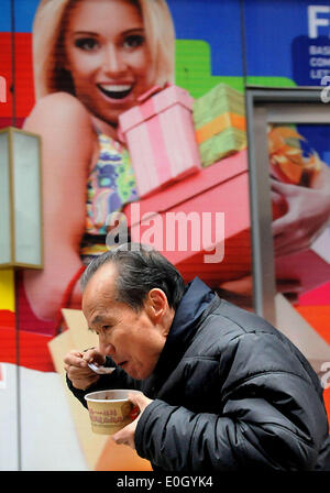 (140513)--Peking, 13. Mai 2014 (Xinhua)--Foto am 1. Januar 2012 zeigt ein Mann Laba Brei während des Gehens auf einer Straße in Zhengzhou, Hauptstadt der Provinz Zentral-China Henan. Chinesen haben die Tradition, am achten Tag des 12. Mondmonats Laba Brei zu essen. Eines der beliebtesten Arten weltweit, chinesisches Essen ist berühmt für seinen Geschmack und Sorte, mit einer unvergleichlichen Auswahl an Essen Stile und Techniken, Zutaten und Gerichte. Die Geschichte des chinesischen Essens erstreckt sich über Tausende von Jahren zurück und hat sich geändert von Zeit zu Zeit und in jeder Region nach Klima, Stockfoto