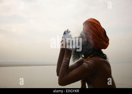 Varanasi, Indien. 13. Mai 2014. Ein Sadhu oder einen hinduistischen heiligen Mann genießt Rauchen am Ufer des Ganges in Varanasi, Uttar Pradesh, Indien, 13. Mai 2014. Varanasi, eine indische Stadt an den Ufern des Ganges in Uttar Pradesh, ist das heiligste der sieben heiligen Städte im Hinduismus und im Jainismus und spielte eine wichtige Rolle bei der Entwicklung des Buddhismus. © Zheng Huansong/Xinhua/Alamy Live-Nachrichten Stockfoto