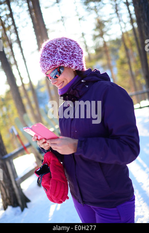 Junge attraktive Frau mit Mobiltelefon im Skigebiet pyhä, Lappland Stockfoto