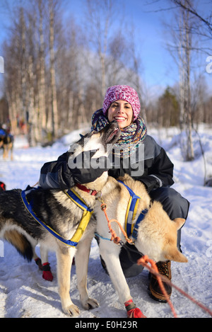 Junge Frau erhält der Liebe von freundlichen Hunde. Wüste husky Hundeschlitten taiga Tour mit bearhillhusky in Rovaniemi, Lappland Stockfoto