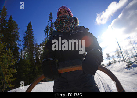 Junge Frau fahren Schlitten. Wüste husky Hundeschlitten taiga Tour mit bearhillhusky in Rovaniemi, Lappland, Finnland Stockfoto