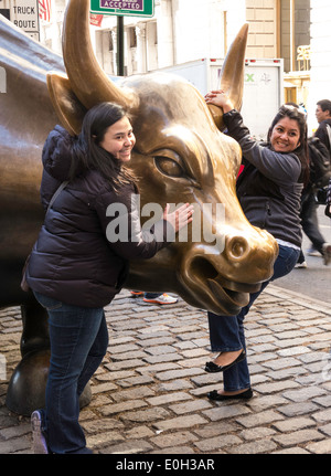 Touristen im Laden Stier Skulptur in Bowling Green Park, New York Stockfoto