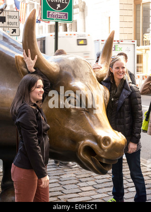 Touristen im Laden Stier Skulptur in Bowling Green Park, New York Stockfoto