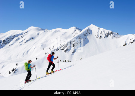 Zwei Backcountry Skifahrer zum Brechhorn, Grosser Rettenstein im Hintergrund, Kitzbüheler Alpen, Tirol, Österreich Stockfoto
