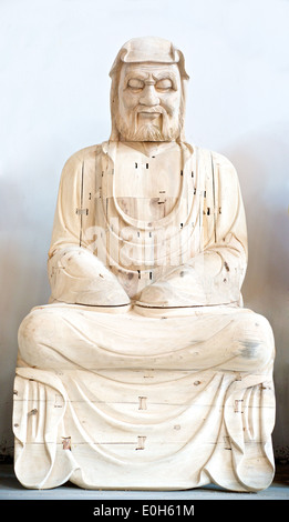 Hölzerne Buddha im Gebet auf weißem Hintergrund Stockfoto