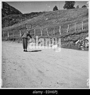 Ein Foto aus der Zeit des Zweiten Weltkriegs mit einem Schild mit der Aufschrift „da Zureden hilft“ in Bezug auf die Kriegsbemühungen und die Moral der Zivilisten während der deutschen Besatzung. Stockfoto