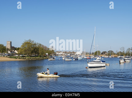 Boote am Hafen von Christchurch mit Christchurch Priory-Kirche in der Ferne Dorset England UK Stockfoto