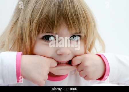 VIER JAHRE ALTEN MÄDCHEN ZIEHEN GESICHTER Stockfoto