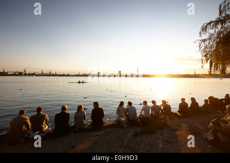 Leute sitzen am Deich bei Alsterperle Café und Bar, Eduard-Rhein-Ufer 1, Außenalster, Hamburg, Germany Stockfoto