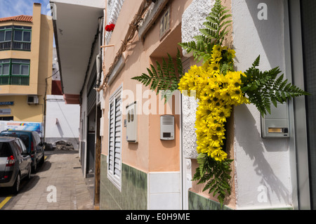 Gelbe Sonnenblumen Kreuz hängend durch die Haustür, el Dia De La Cruz, ein religiöses fest auf Teneriffa zu feiern, Stockfoto