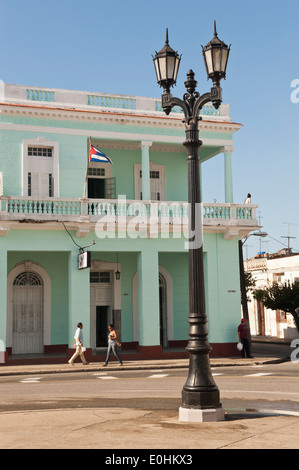 Cienfuegos Stadt square Straßenszene mit alten Lampe und Einheimischen zu Fuß entlang der Straße und kubanische Flagge Stockfoto