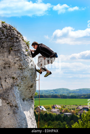 Extreme Klettern, Mann auf natürliche Mauer mit blauem Himmel. Stockfoto