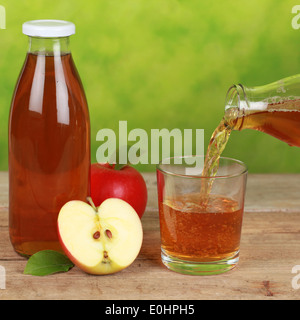 Apfelsaft ist aus der Flasche in ein Glas gießen. Stockfoto