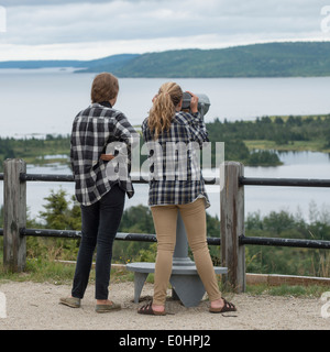 Mädchen auf der Suche im Blick auf die Bucht durch ein Münz-Fernglas, Joey es Lookout, Gambo, Neufundland und Labrador, Kanada Stockfoto