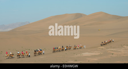 Touristen, Kamelreiten auf berühmte Shan, Dunhuang, Jiuquan, Provinz Gansu, China Stockfoto