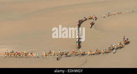 Touristen, Kamelreiten auf berühmte Shan, Dunhuang, Jiuquan, Provinz Gansu, China Stockfoto