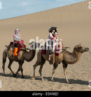 Touristen, Kamelreiten auf berühmte Shan, Dunhuang, Jiuquan, Provinz Gansu, China Stockfoto
