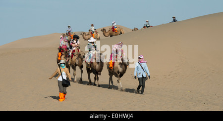 Touristen, Kamelreiten auf berühmte Shan, Dunhuang, Jiuquan, Provinz Gansu, China Stockfoto