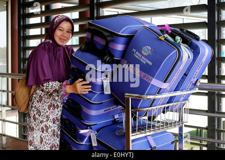 Beifahrerin mit passender Kleidung und Gepäck am internationalen Flughafen Soekarno-Hatta Jakarta Indonesien Stockfoto