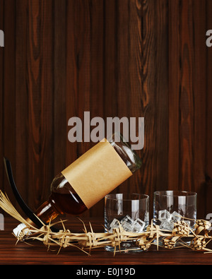 Zwei Gläser mit Eis für Whiskey und Flasche auf dunklem Holz. Stockfoto