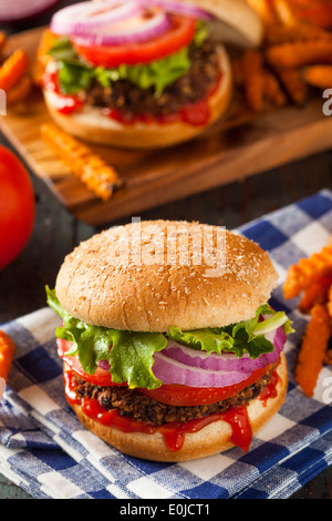 Hausgemachte gesunde vegetarische Quinoa-Burger mit Salat und Tomate Stockfoto