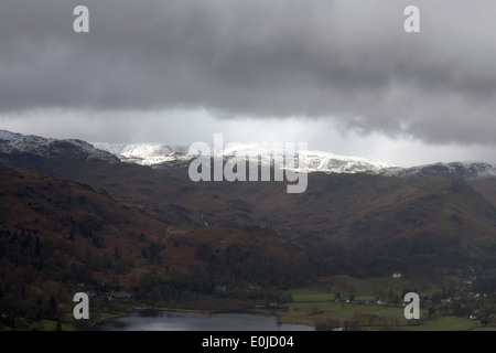 Gewitterwolken über Grasmere mit Spitze Felsen im Hintergrund aus Loughrigg fiel Seenplatte Cumbria England Stockfoto