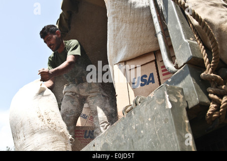 Ein pakistanischer Soldat entlädt einen Beutel mit Mehl auf ein US-Marine MH-53E Hubschrauber, die 15. Marine Expedit zugewiesen werden Stockfoto