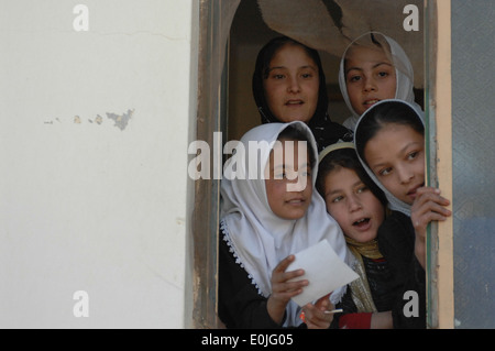 Eine Gruppe von afghanischen Frauen, Studenten Jan Qadam Dorfschule, beobachten Sie, wie Mitglieder der Operation Pflege Build eine Wache, um verwendet werden zu vergießen Stockfoto