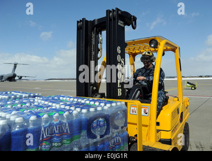 Petty Officer 1st Class Steven DeMay, Luftfahrt Bootsmännern Paaren (Handhabung), schleppt eine Palette von Mineralwasser in Richtung einer MH-53E Hel Stockfoto