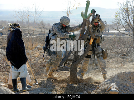 Einige Dorfbewohner einen Baum während einer Kanal-Site-Übersicht in der Nähe Autobahn zu entfernen helfen Staff Sgt Sean Quigley, links, und Jonathan Reed Spc. Stockfoto