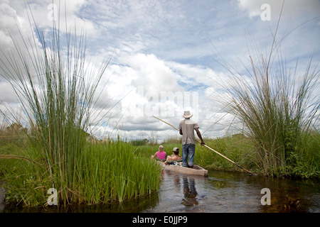 Touristen auf einem traditionellen Mokoro Boot in das Okavango Delta, Botswana, Afrika Stockfoto