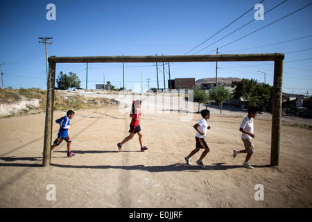 Tijuana. 13. Mai 2014. Bild aufgenommen am 13. Mai 2014 zeigt Spieler Aldama Fußball Team Zug auf einem Feld ohne Rasen unter der Regie von Trainer Oscar Fregoso in der Stadt Tijuana, nordwestlich von Mexiko. Seit 2002 wurde der Trainer, den Oscar Fregoso beauftragt, Kinder und Jugendliche in Mariano Matamoros und El Pipila Neighboorhood Fußball spielen und arbeitete auch für, den Boden in Bereichen, wo die Leute Fußball üben können. © Guillermo Arias/Xinhua/Alamy Live-Nachrichten Stockfoto