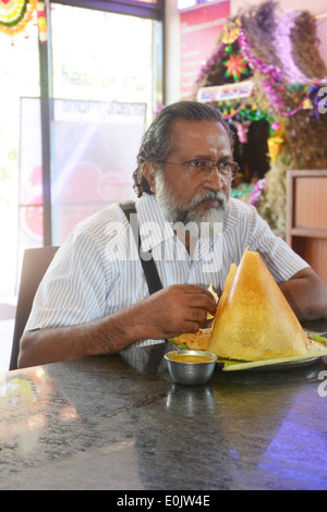 Mann isst dosa Stockfoto