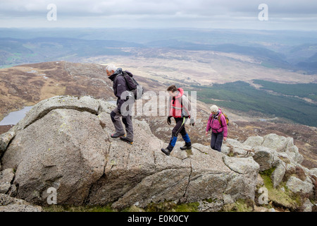 Drei Wanderer kriechen, über Felsen auf Carnedd Moel Siabod Daear Ddu Grat in Berge von Snowdonia National Park North Wales UK Stockfoto