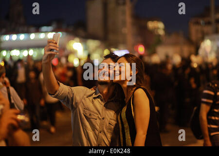 15. Mai 2014 - Istanbul, Türkei - dauert ein türkische paar ein Foto von sich mit der türkischen Polizisten im Hintergrund am Taksim Platz während einer Protestaktion gegen die Bergbau-Katastrophe in Soma, Türkei, die am 15. Mai 2014 mehr als 245 türkische Menschen getötet worden. Erklärte die Türkei drei Tage der Trauer am 14. Mai, als die Zahl der Todesopfer durch des Landes schlimmste Bergbau Katastrophe in mehr als zwei Jahrzehnten erreichte mehr als 245, mit Ängsten, die die Zahl viel höher klettern konnte. Stockfoto