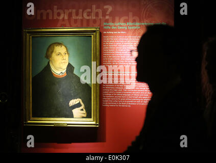 Altenburg, Deutschland. 15. Mai 2014. Ein Mann steht neben einem Porträt von Martin Luther in der Ausstellung über Georg Spalatin (1484-1545) in Altenburg, Deutschland, 15. Mai 2014. Die vier Bände sind illustriert mit über 1800 Zeichnungen aus der Cranach-Werkstatt und erzählen die Geschichte von Sachsen, Thüringen und Meißen. Die Ausstellung "Georg Spalatin - Steuermann der Revolution" ist geöffnet von 11 Mai bis 2. November 2014 schloss Altenburg. Spalatin arbeitete im Hintergrund der Diplomatie und organisiert für Luther zu Wartburg kommen. Foto: JAN WOITAS/Dpa/Alamy Live News Stockfoto