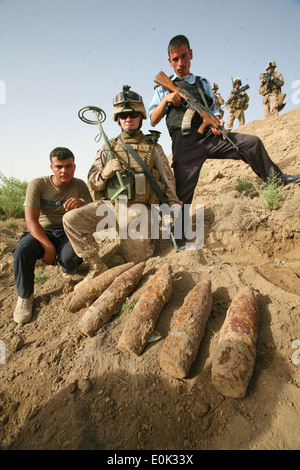 Ein US-Marine-Ingenieur an Alpha Company, 1. Bataillon, 7. Marineregiment und irakische Polizisten posieren mit Artillerie ro Stockfoto