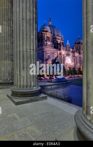 Der Dom (Berliner) durch die Säulen des alten Museums in der Nacht. Stockfoto