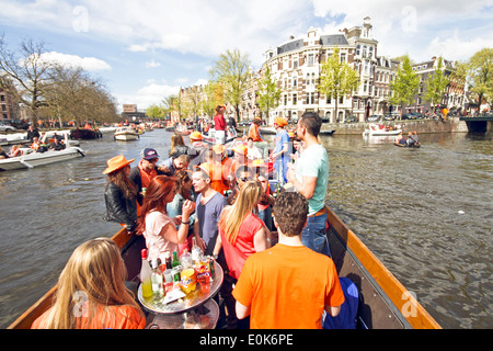 Grachten voller Boote und Menschen in Orange während der Feier der Königinnentag am 30. April 2013 in Amsterdam Niederlande Stockfoto