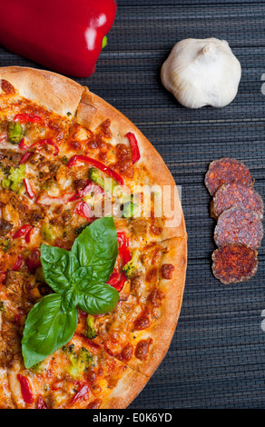 Leckere Pizza mit Brokkoli und Paprika auf dunklem Hintergrund Stockfoto