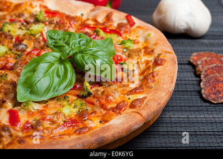 Leckere Pizza mit Brokkoli und Paprika auf dunklem Hintergrund Stockfoto