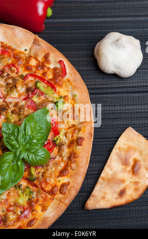 Leckere Pizza mit Brokkoli und Paprika auf dunklem Hintergrund Stockfoto