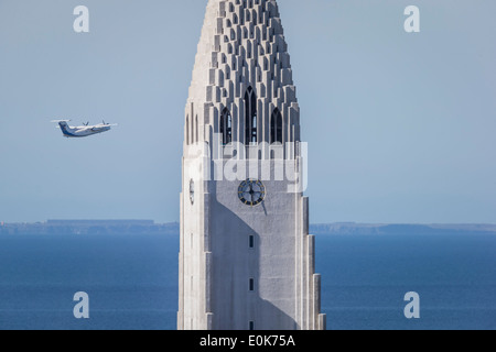 Kleines Flugzeug in der Nähe der Turm der Kirche Hallgrimskirkja, Reykjavik, Island Flugzeug De Havilland Canada Dash 8 bombardier Stockfoto