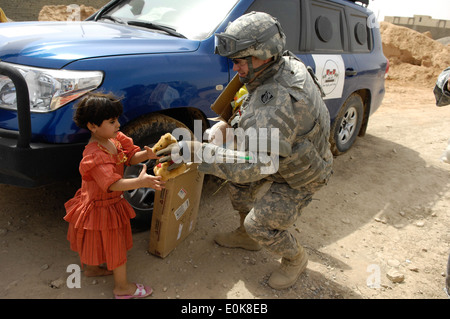 US Armee-Oberstleutnant Dwight Davies von Chicago, Illinois, von der US Army Corps of Engineers, vertreibt Spielzeug für Kinder ne Stockfoto