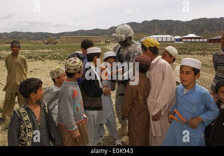 Provinz PAKTIKA, Afghanistan – US Armee Sgt. Terrance Ray liest ein Buch für Kinder während auf einer Mission im Orgun, Paktik Stockfoto