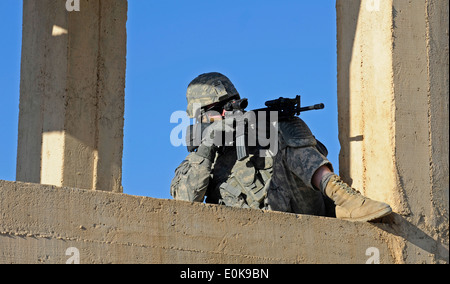 SPC. Timothy Leary zieht Sicherheit an einem Wasserturm, während Mitglieder der Provinz Zabul der Wiederaufbau-Team eine Qualität sicher durchführen Stockfoto