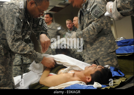 Armee-medizinisches Personal behandelt, einer der Überlebenden der Salang Pass-Lawine auf die Triage auf dem Flugplatz Bagram in Par Stockfoto