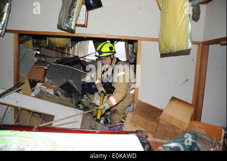 Ein Mitglied von Fairfax County Urban Search and Rescue Team schiebt beiseite Möbel und Rubel bei der Suche nach Überlebenden, hier, Stockfoto