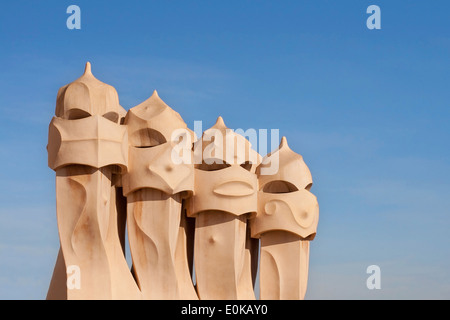 Schornsteine auf dem Dach des Casa Mila gegen einen klaren Himmel in Barcelona. Stockfoto